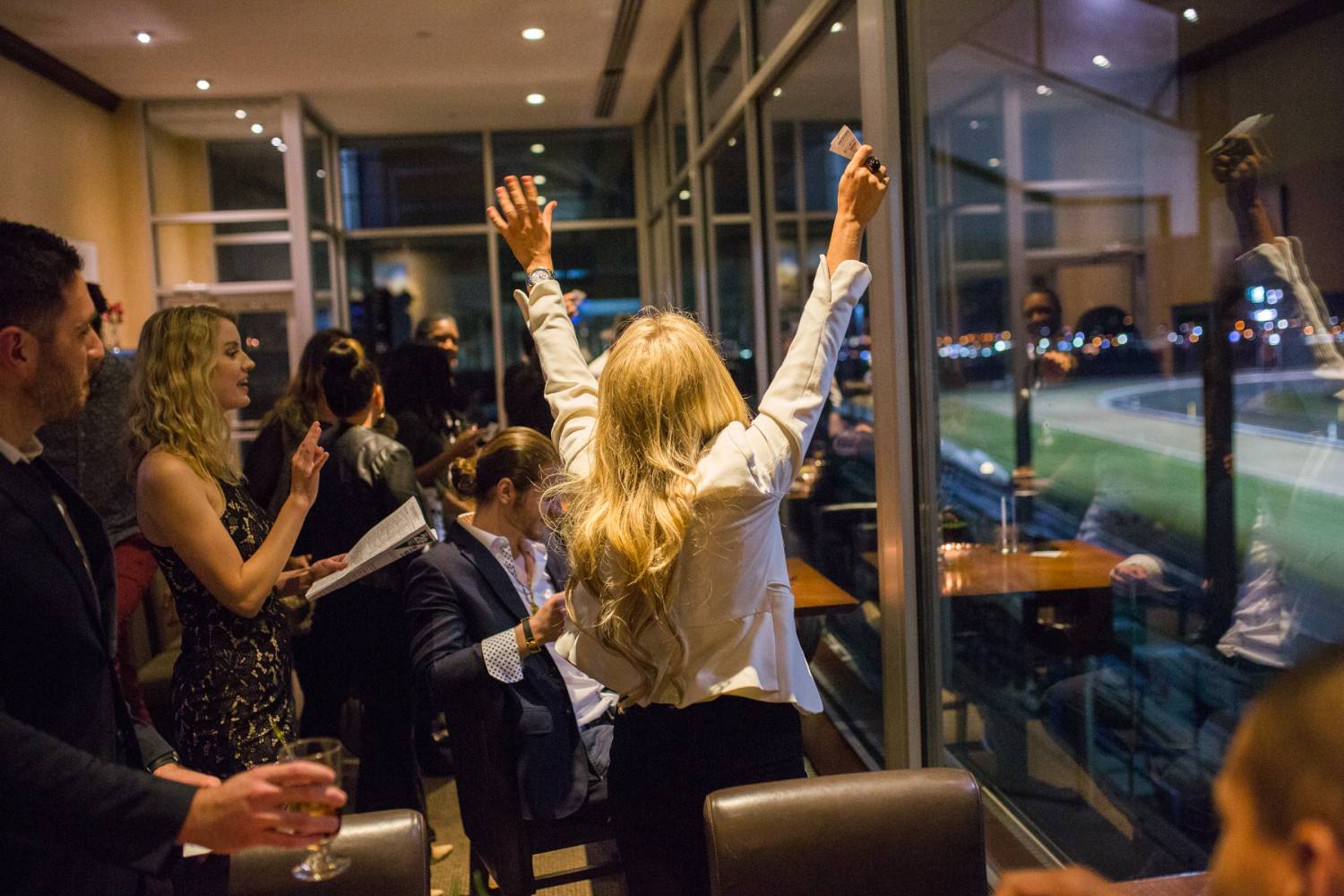 a woman cheering in the woodbine club suite